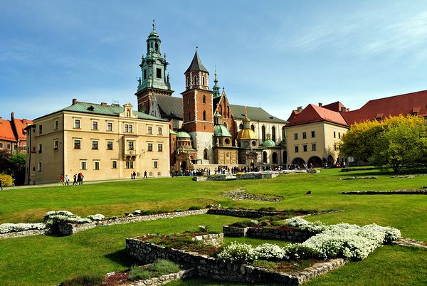 People walk around historic buildings in Krakow Poland