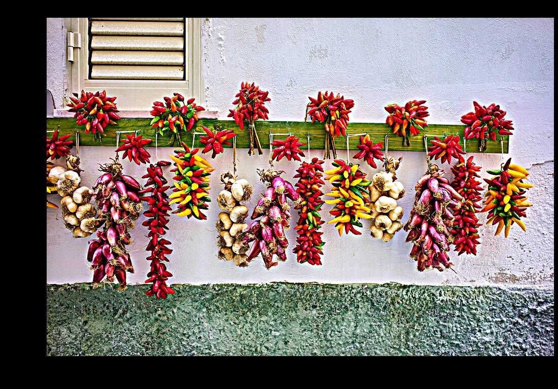 Vieste Gargano. Apulia Puglia Italy. Red chilishallot and garlic hanged to dry outside a house