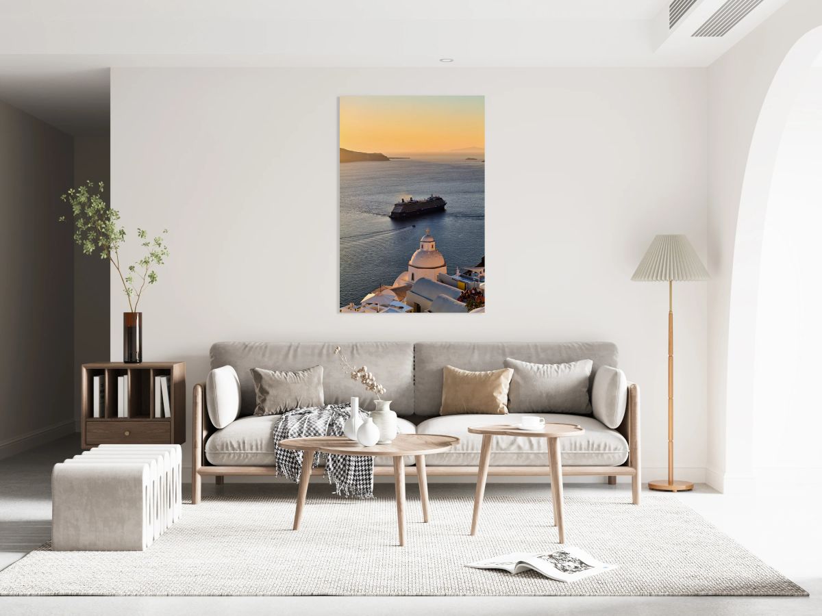 Cruise ship sails past Santorini dome at sunset.