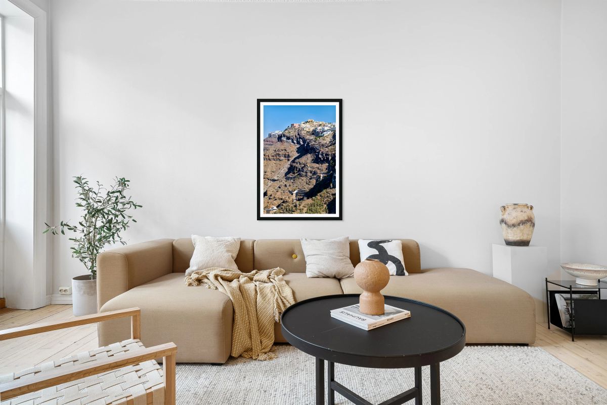 Santorini cliffside town with cable car and winding paths.