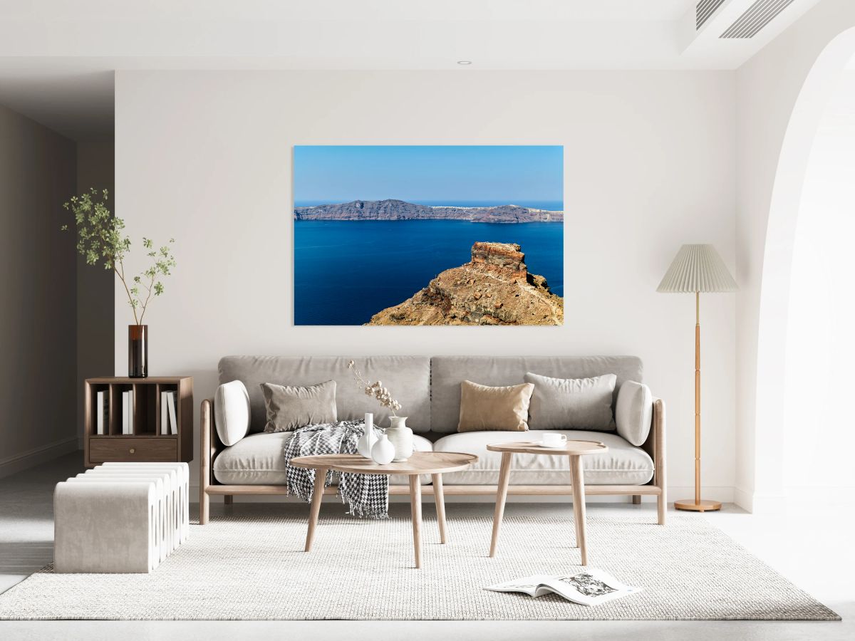 Santorinis volcanic caldera deep blue sea and distant island.