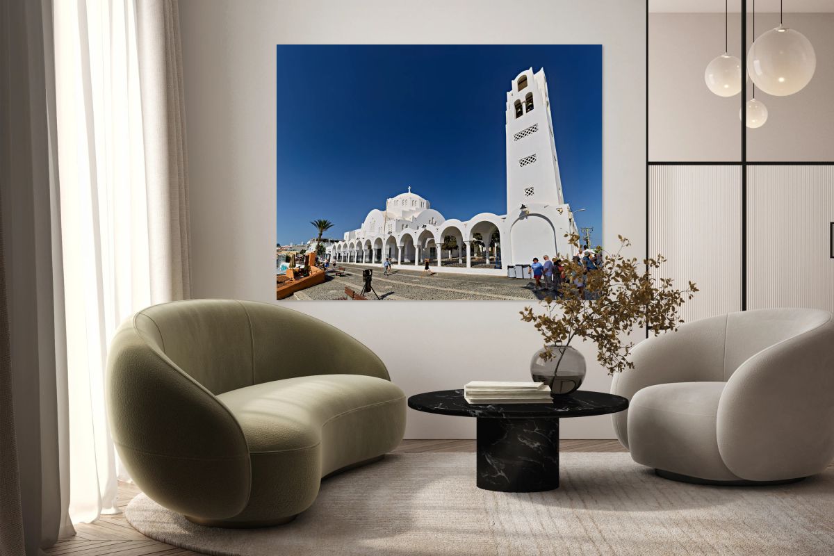 Iconic white church in Santorini under a bright blue sky.