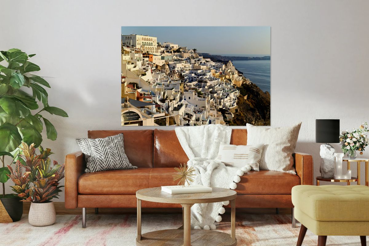 Santorinis white buildings cascade down cliff to the sea.