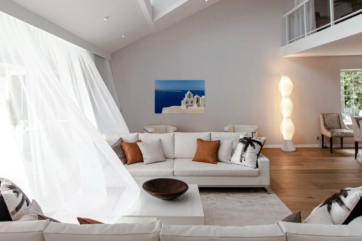 Santorini bell tower with caldera view and deep blue sea.