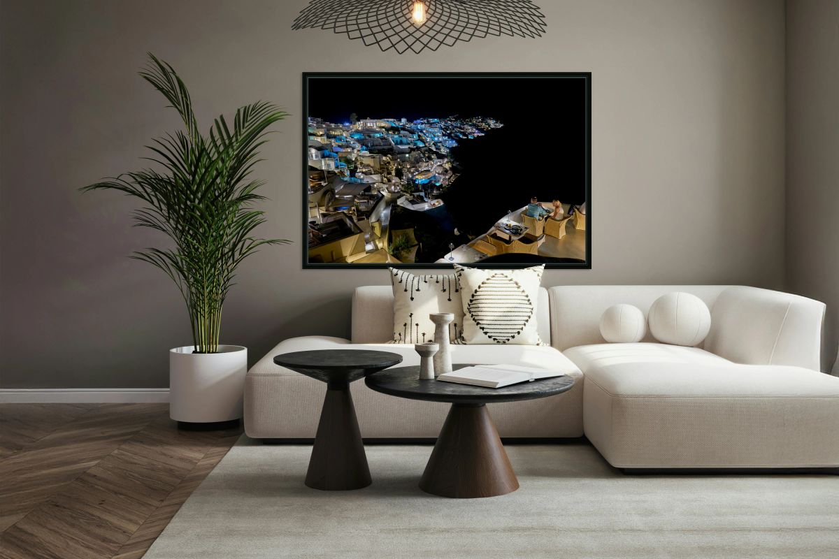 Illuminated cliffside town at night couple enjoying dinner.