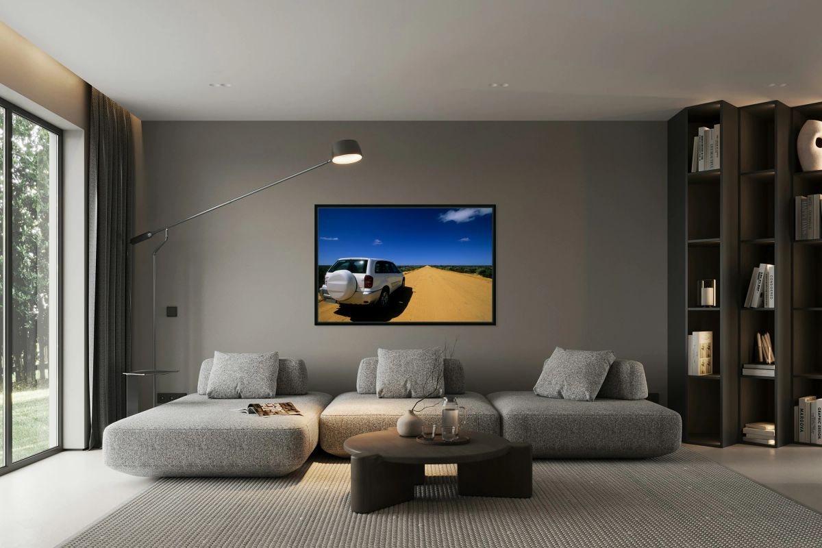 A white SUV on a long straight outback road.