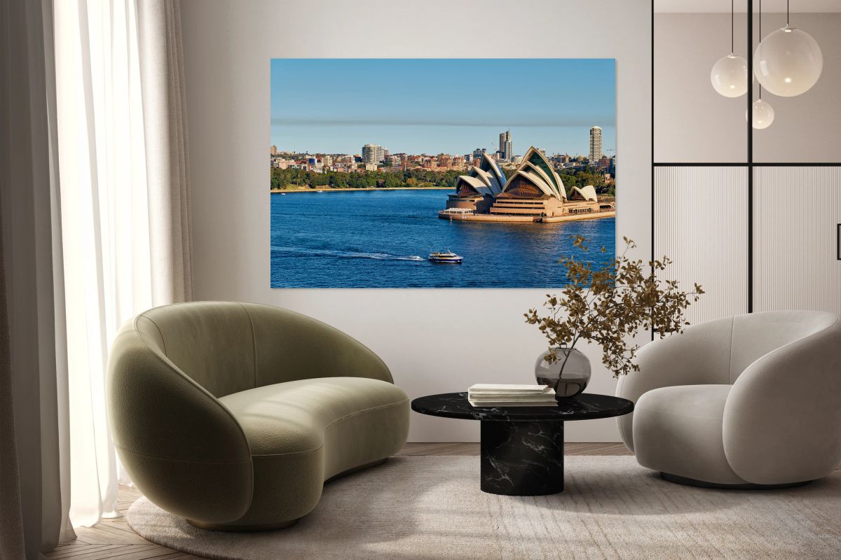 Sydney Opera House and harbor with ferry on a sunny day.