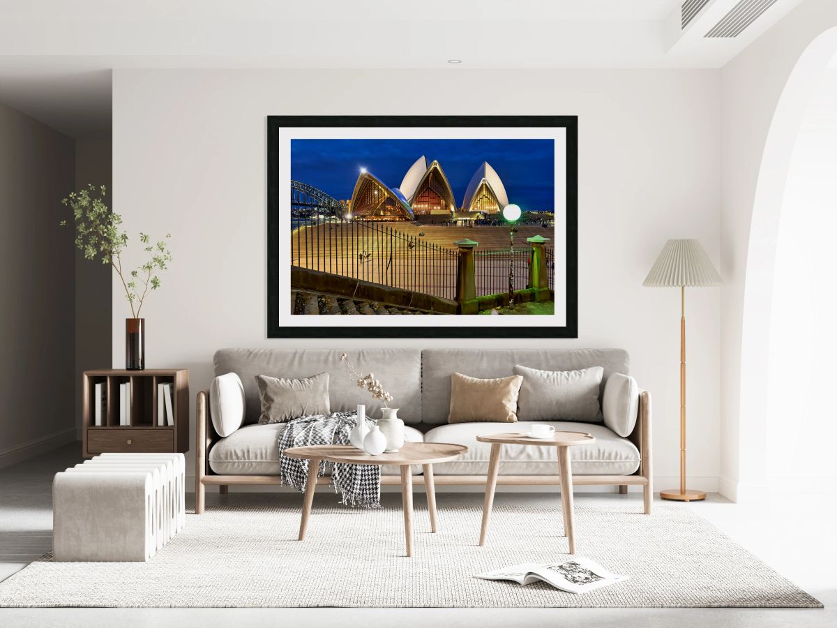 Sydney Opera House illuminated at dusk with crowds on steps.