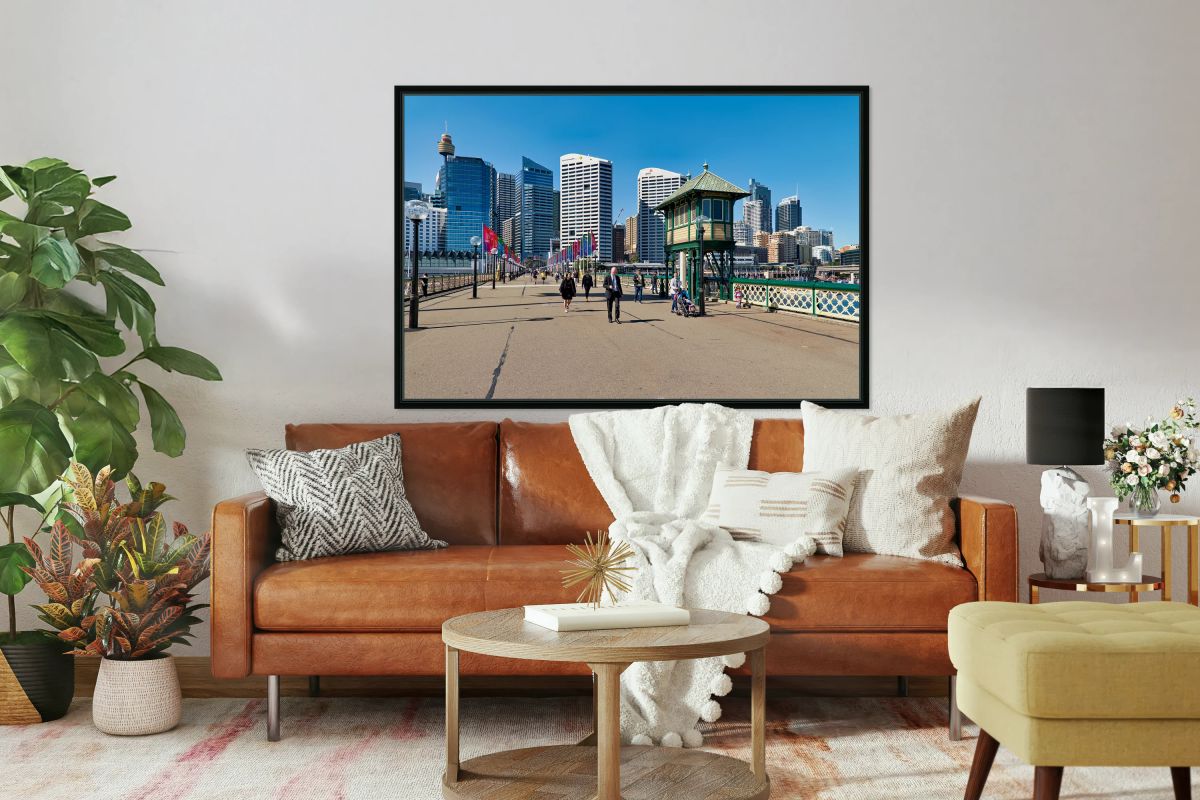 People walk on a sunny day with Sydney skyline.