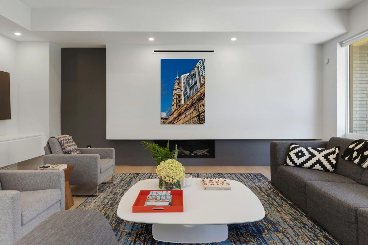 Historic clock tower stands tall against modern buildings.