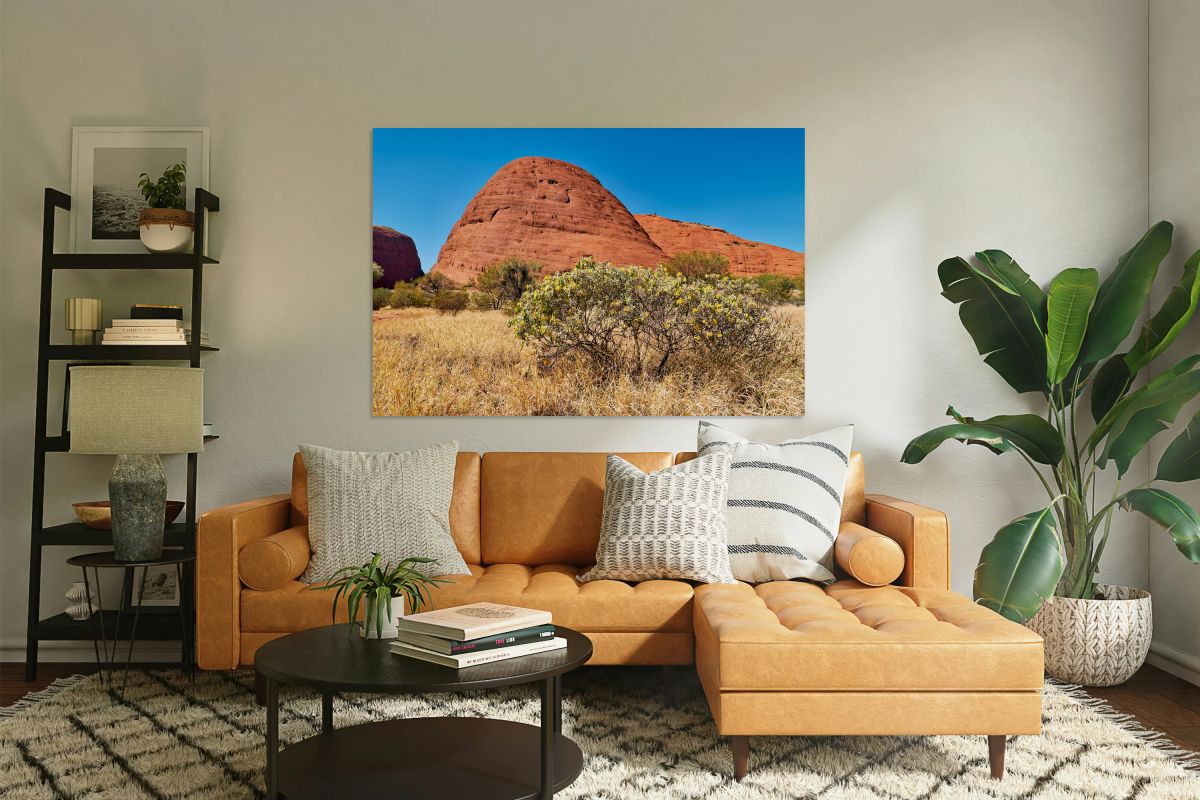Red rock formations with yellow flowers under a blue sky.