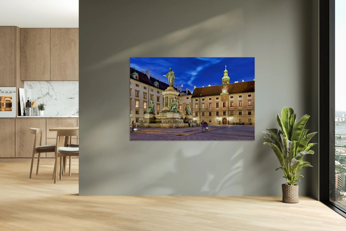 Monument in illuminated Hofburg courtyard Vienna at night.