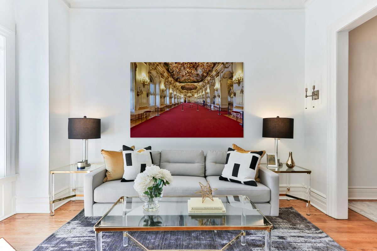 Stunning gilded palace hall with red carpet and chandeliers.