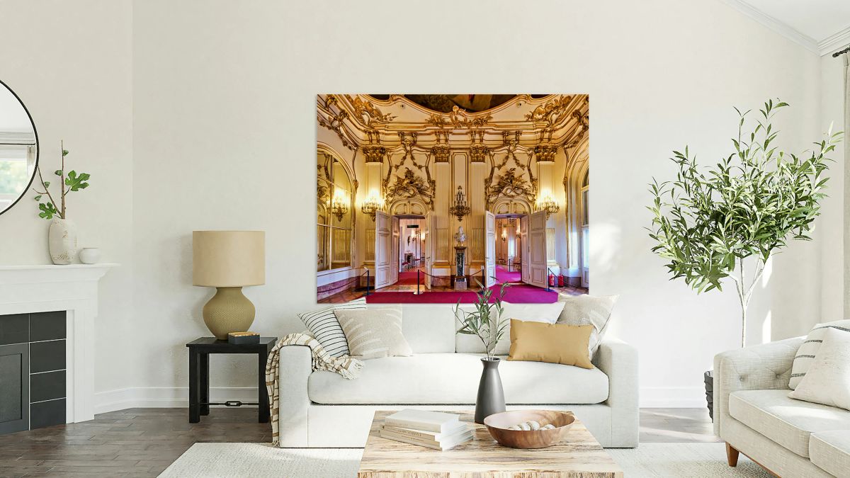 Opulent gold adorned palace room with open doors and red carpet