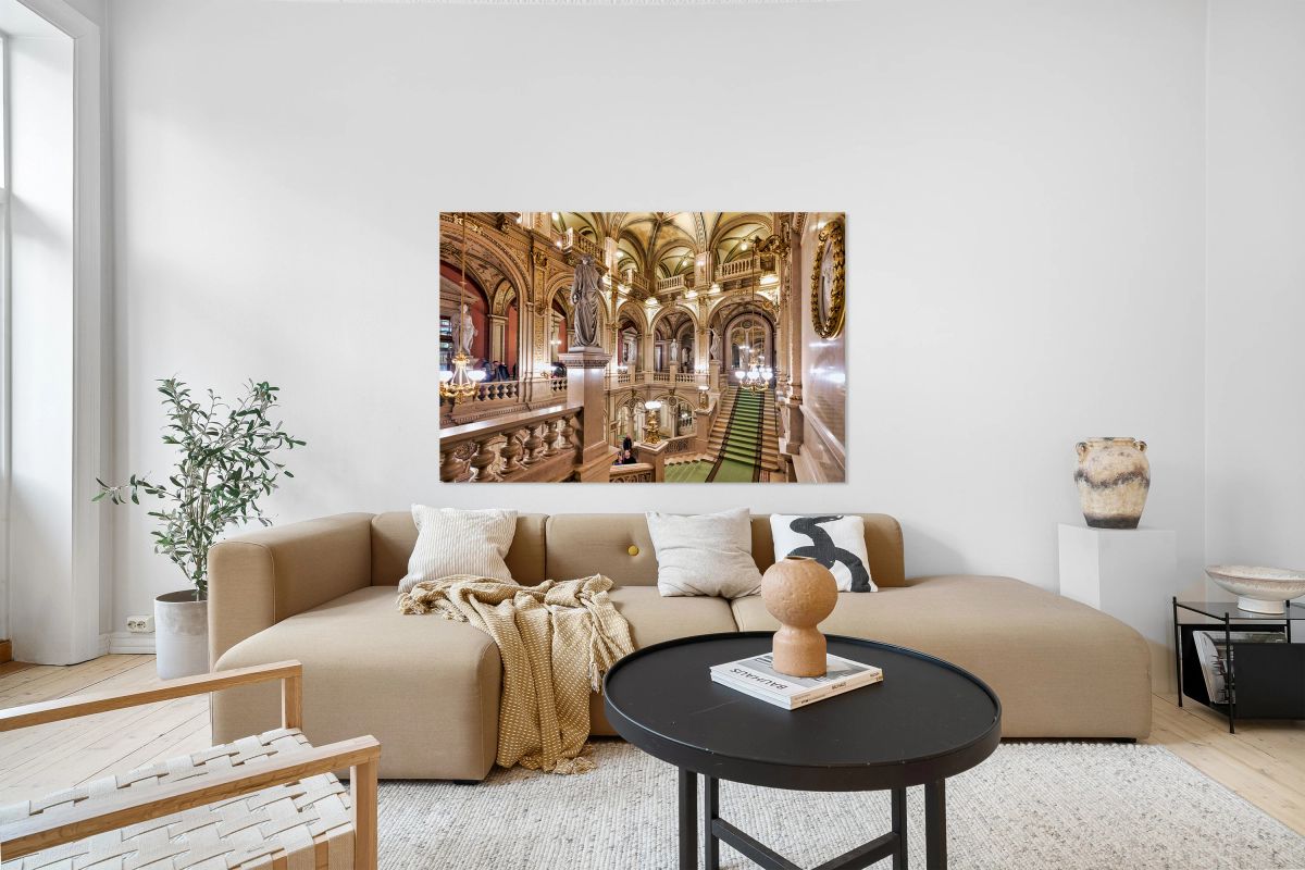 Luxurious opera house interior with grand staircase and statues.