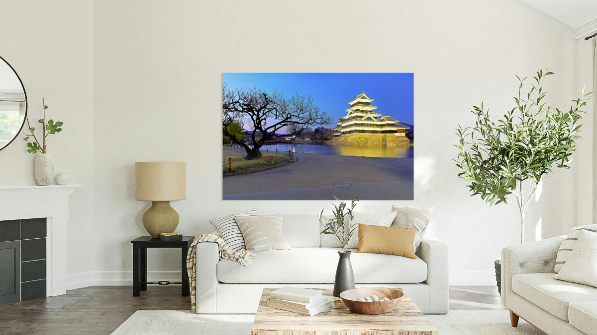 Matsumoto Castle stands by a river at sunset in Japan