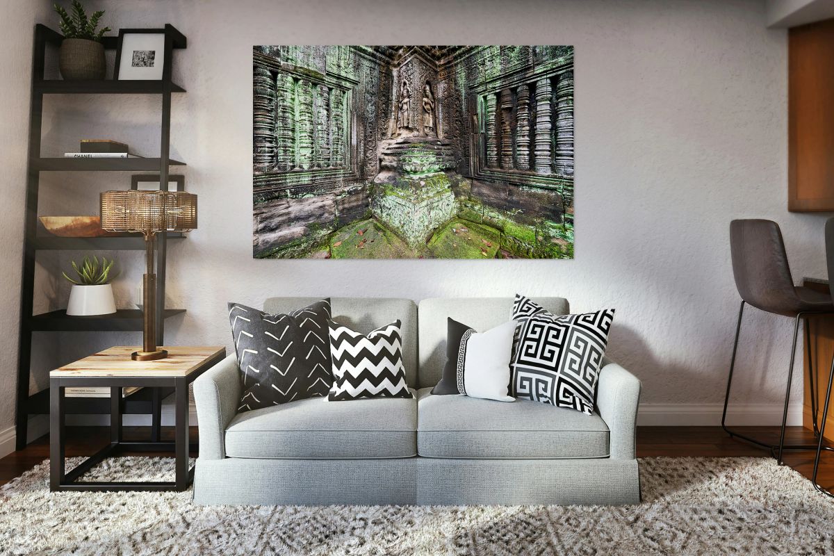 Ancient temple carvings covered in vibrant green moss.