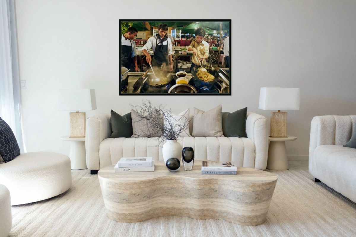 Three chefs cook steaming street food in woks at night.