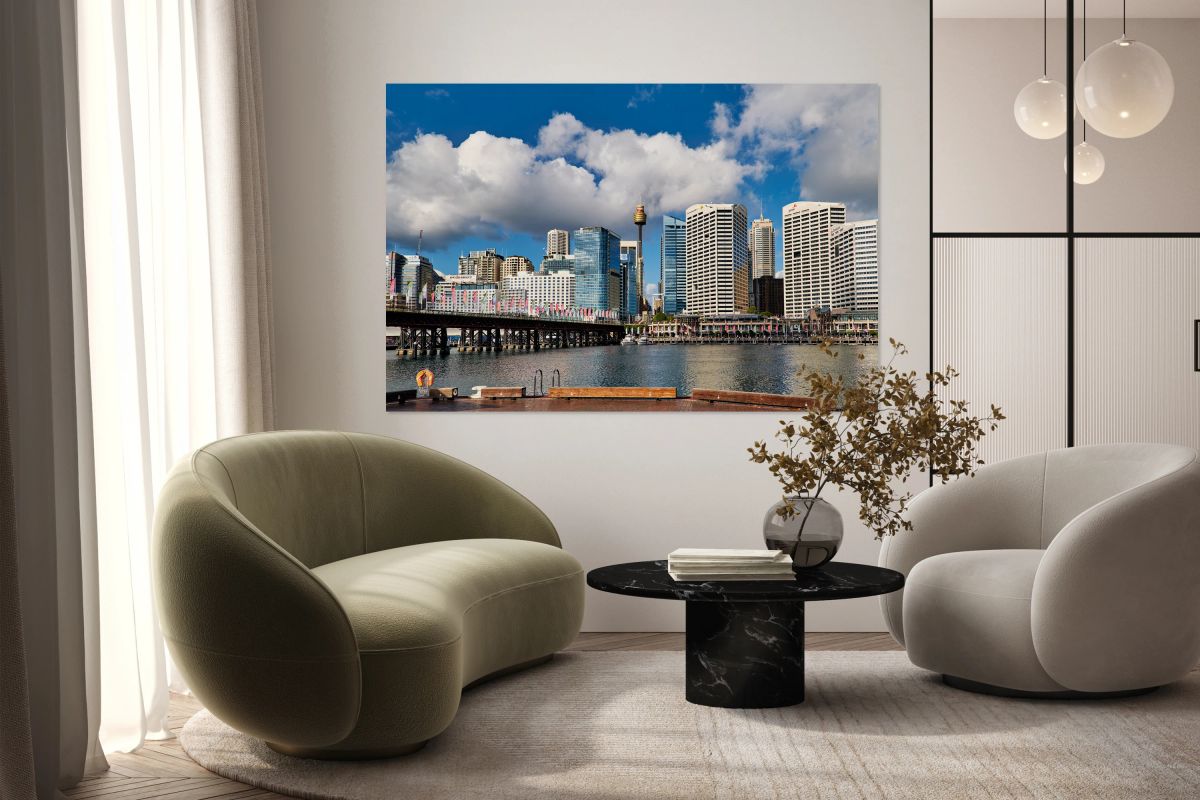 Sydney Harbour skyline with bridge and buildings under clouds.