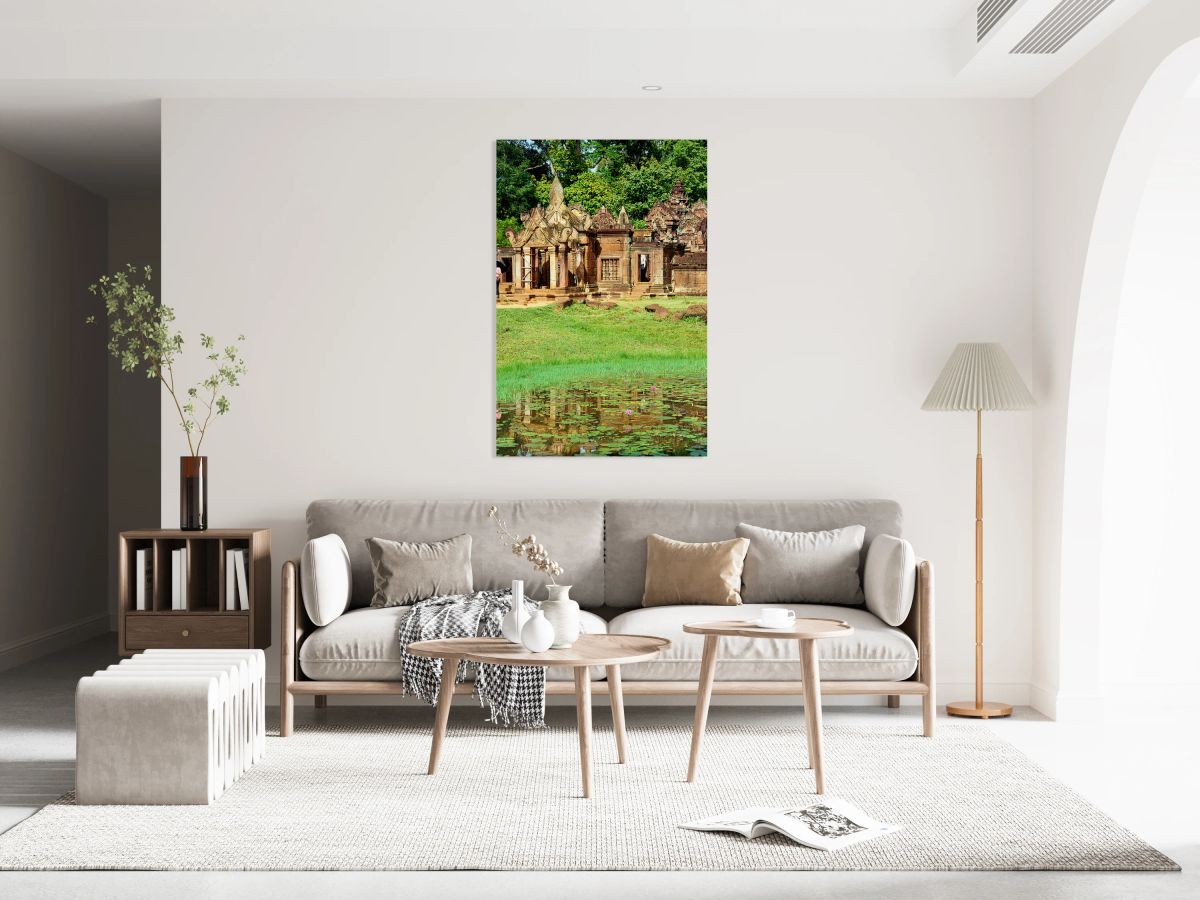 Ancient Cambodian temple reflected in a pond with water lilies.