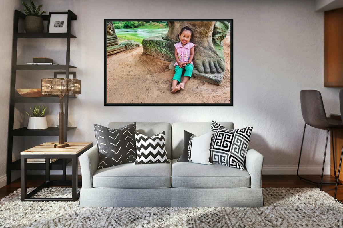 Smiling girl sits by ancient stone structure.