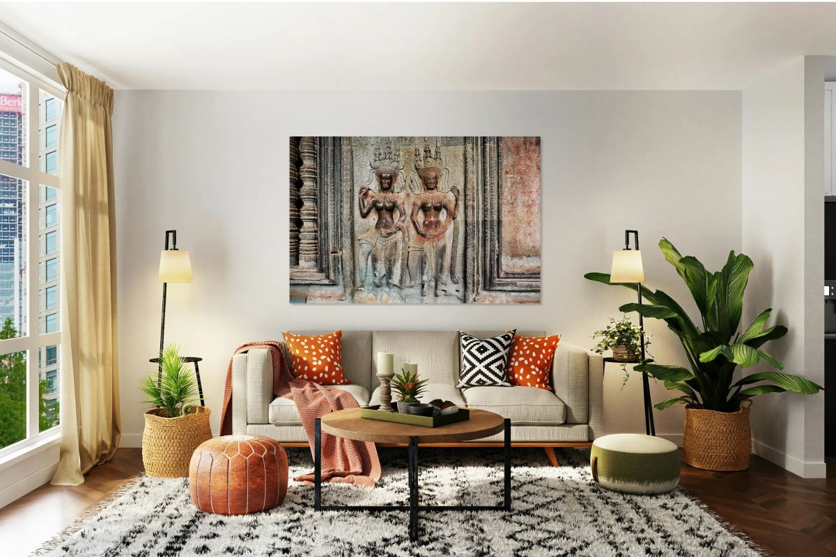 Two ornate Apsara carvings on an ancient temple wall.