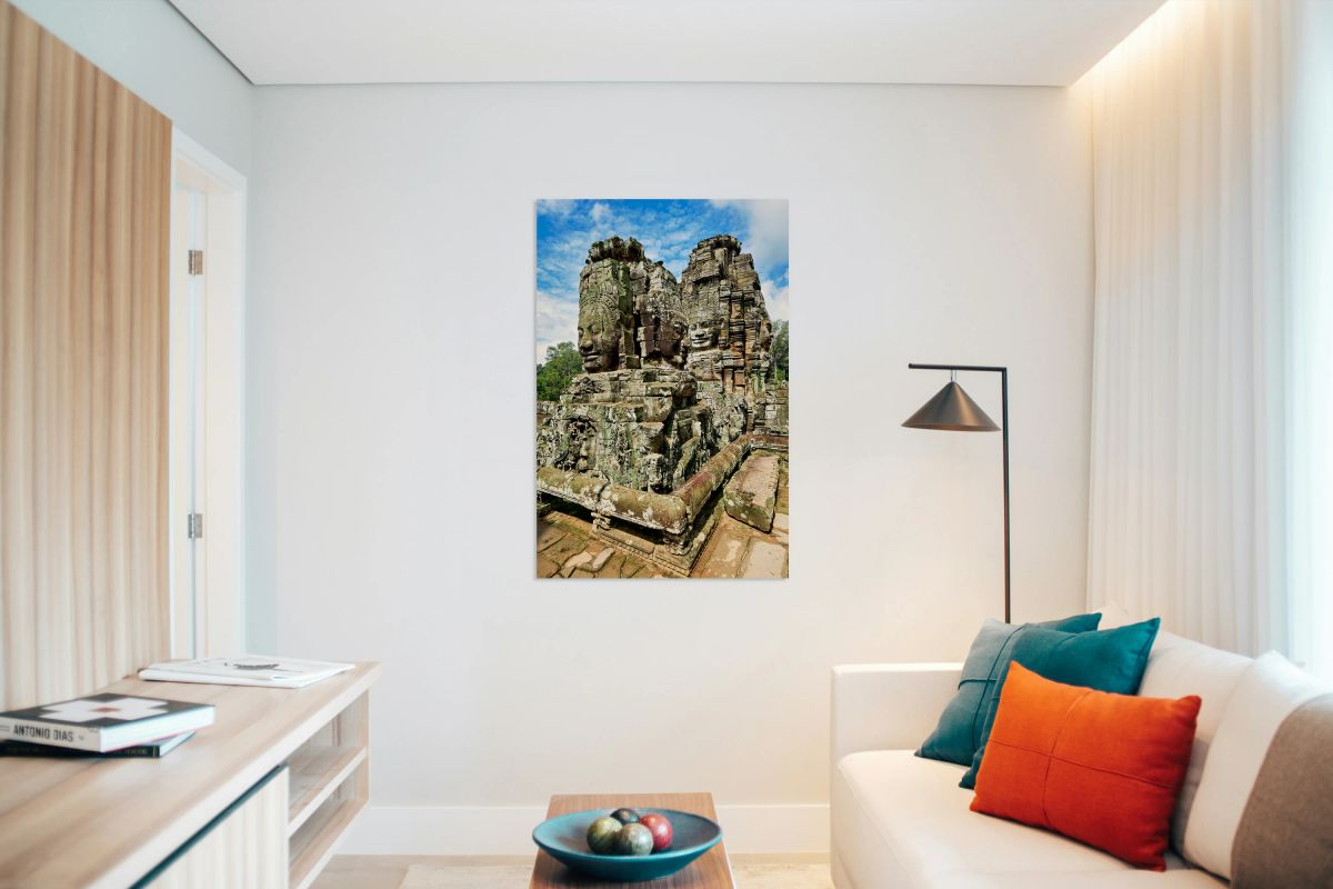 Ancient Khmer temple with carved stone faces.