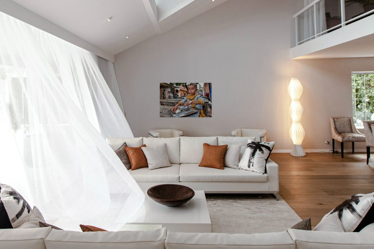 Child in traditional dress eating rice outdoors.