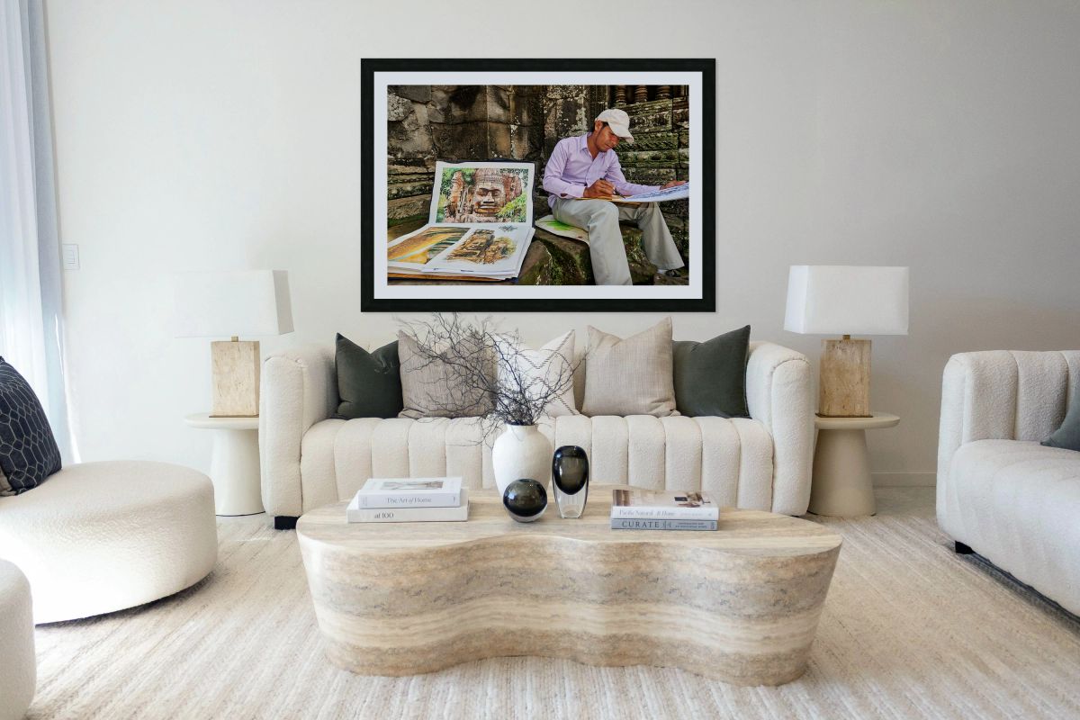 Artist drawing ancient temple carvings outdoors.