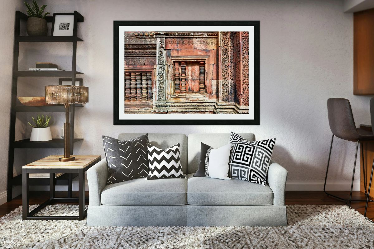 Ancient temple wall with intricate reddish stone carvings and co