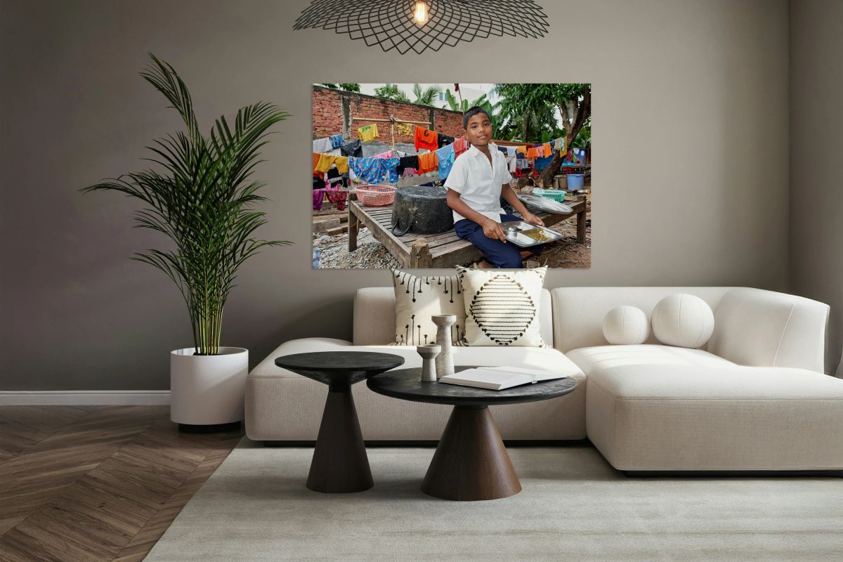 Boy with food tray clothes drying in background.