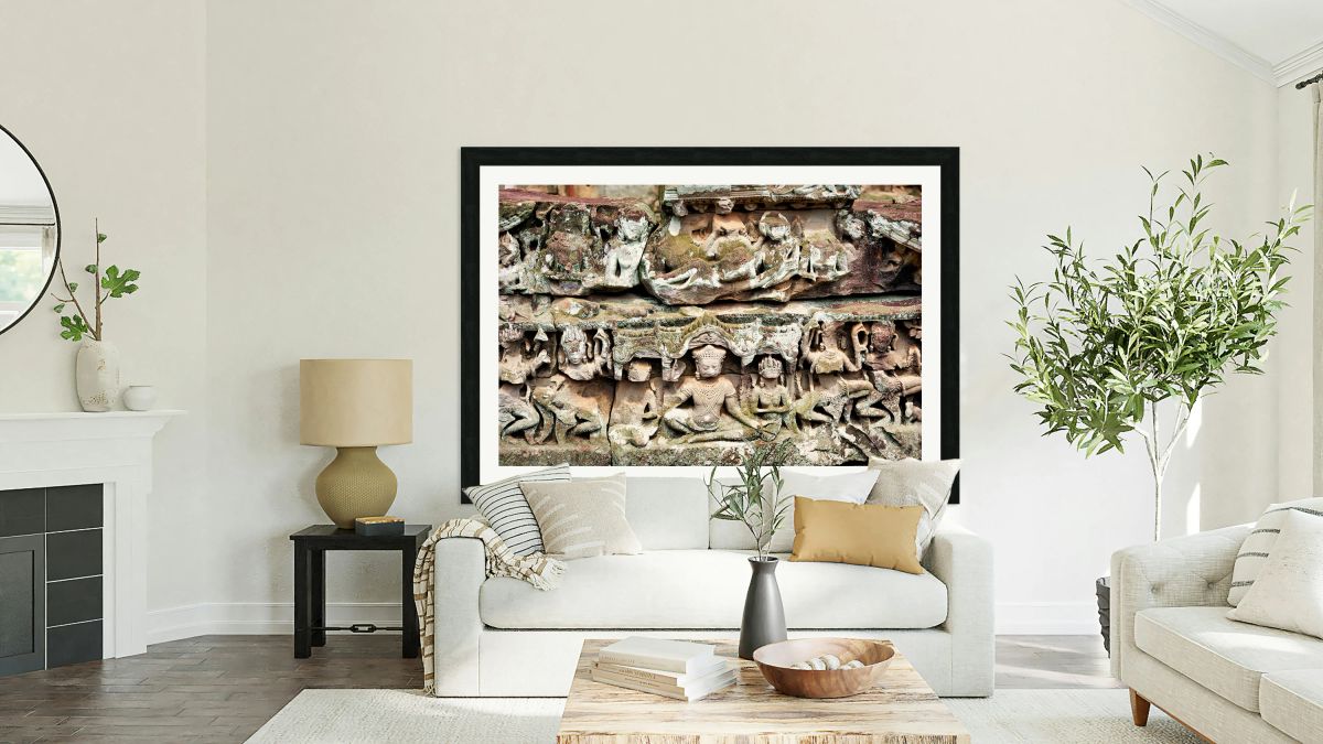 Intricate ancient stone carvings on a moss covered temple.