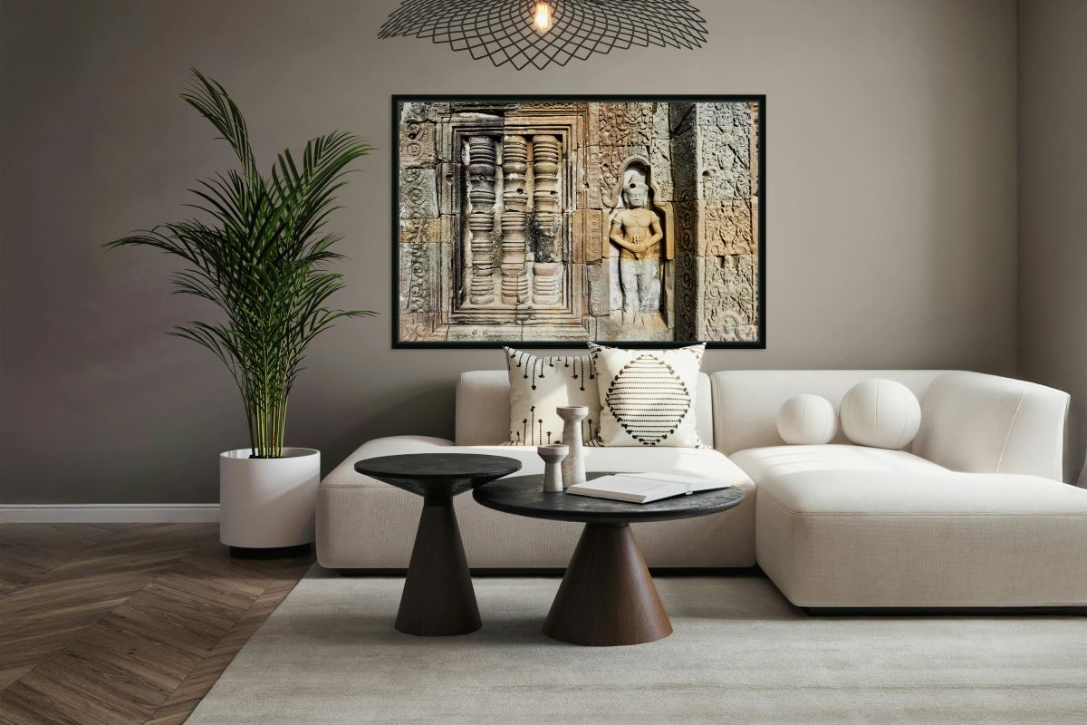 Ancient temple wall with intricate stone carvings and a figure.