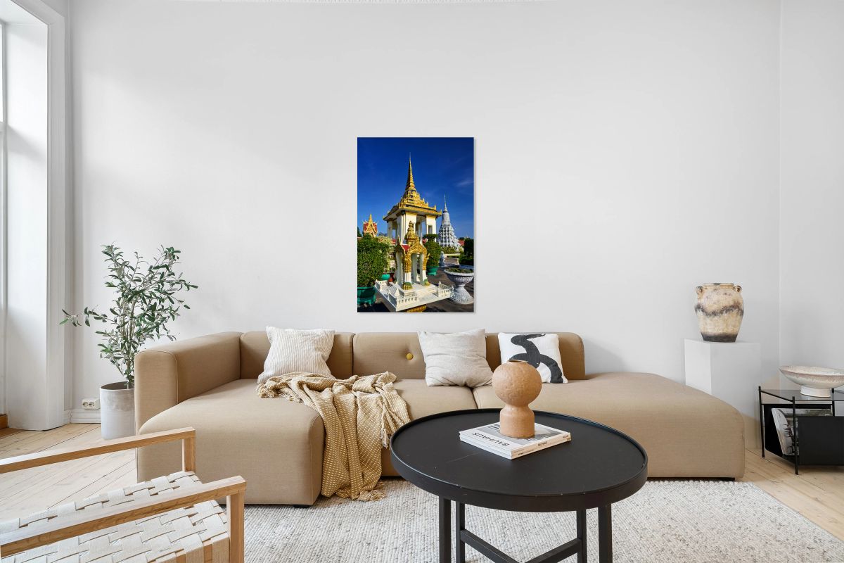 Golden temples and a grey stupa under a clear blue sky.
