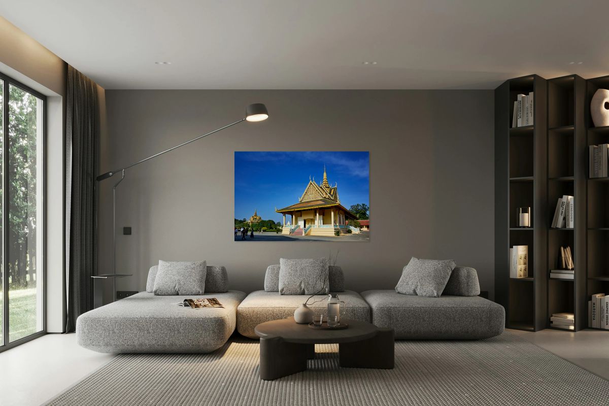 Ornate Cambodian temple under clear blue sky with visitors.