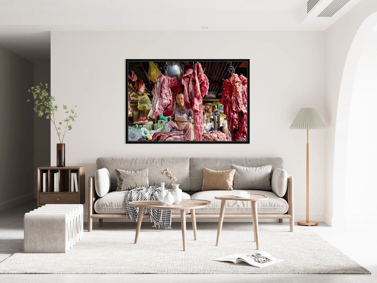 Woman selling raw meat in a bustling market.