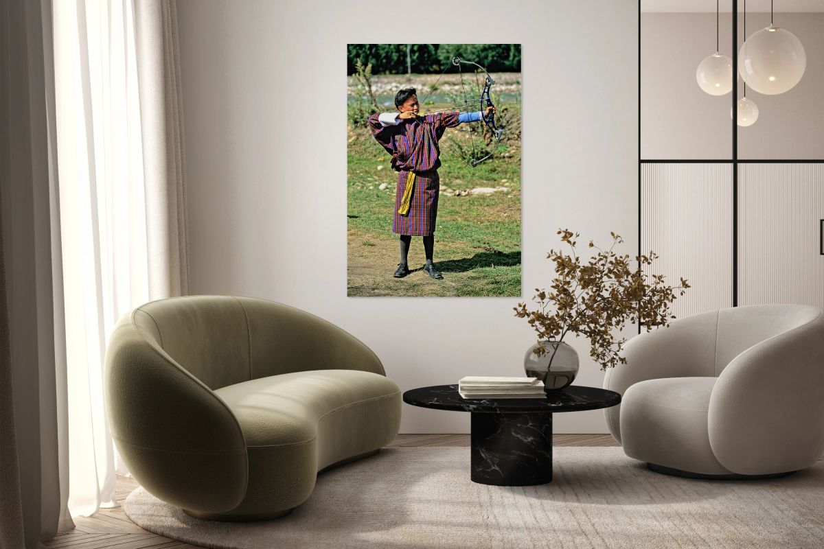 Bhutanese archer in traditional Gho aiming a compound bow.