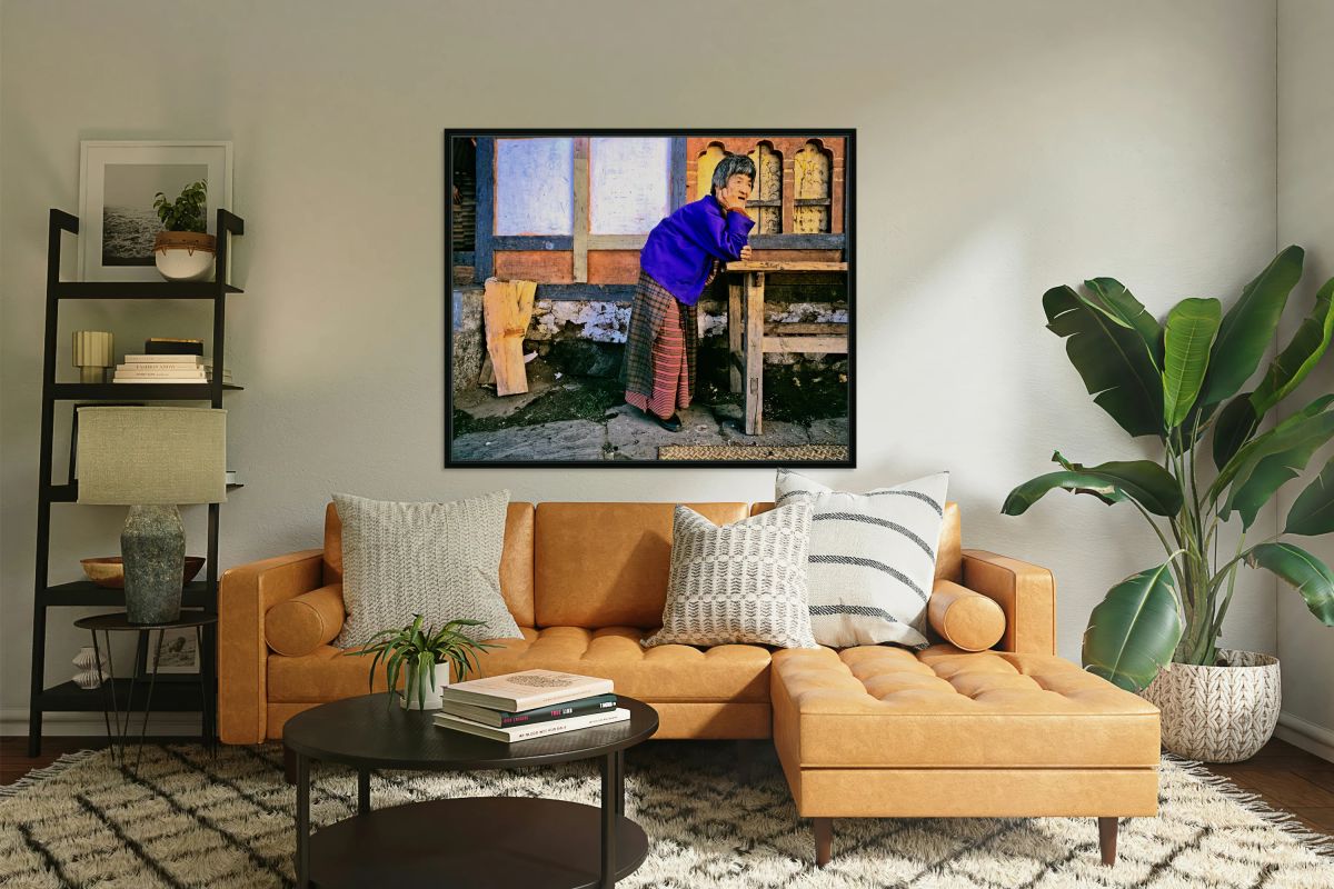 Smiling elderly woman in traditional dress leaning on wooden tab