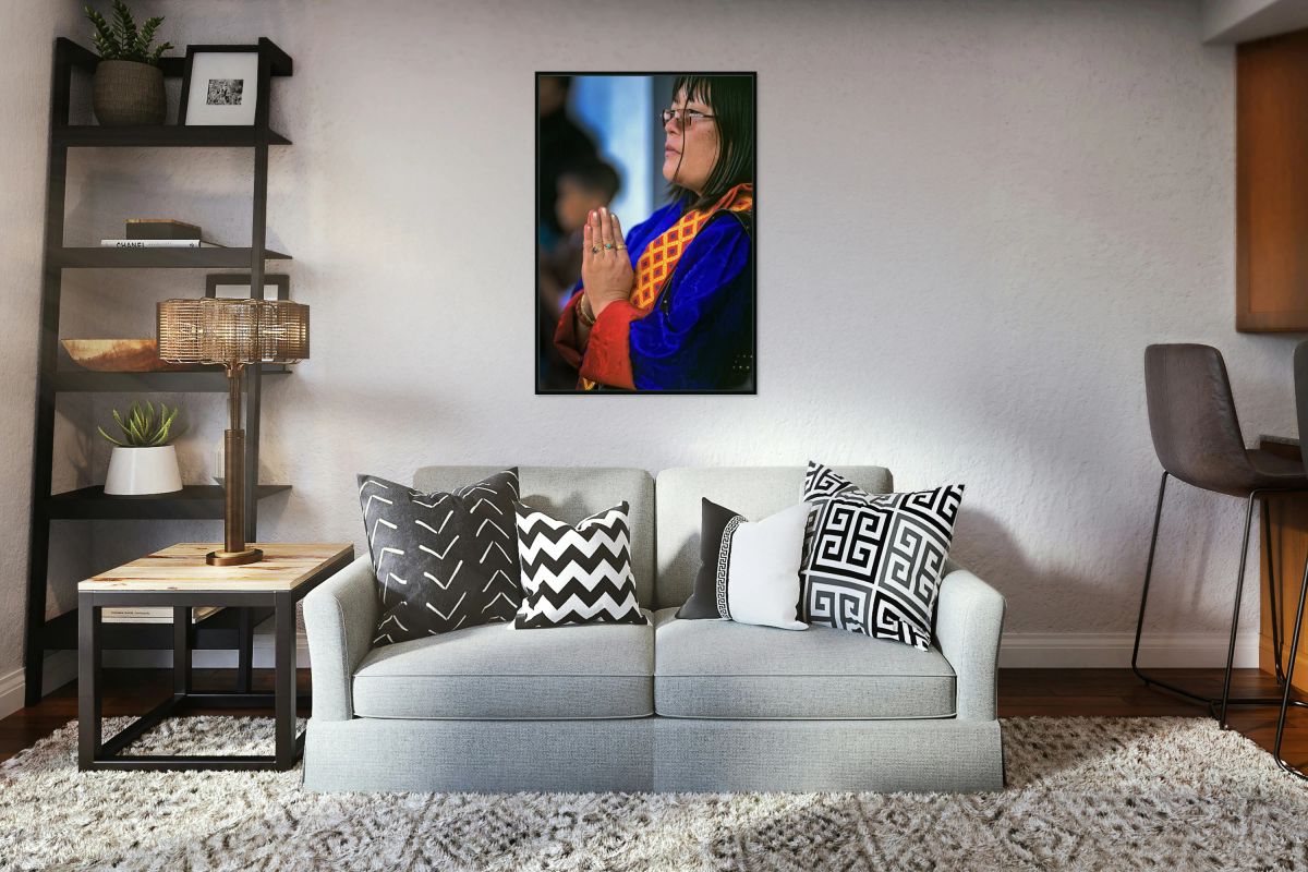 Woman in traditional dress with hands clasped in prayer.
