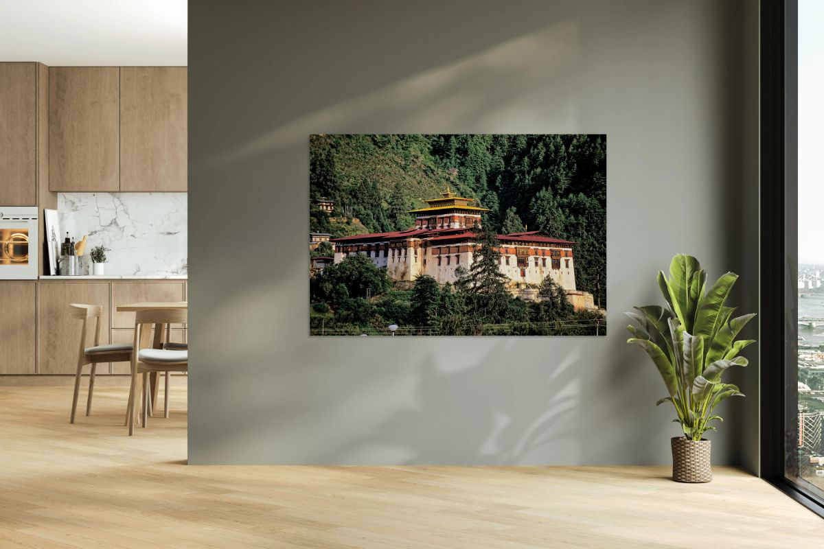 Majestic Bhutanese dzong amidst dense green forest.