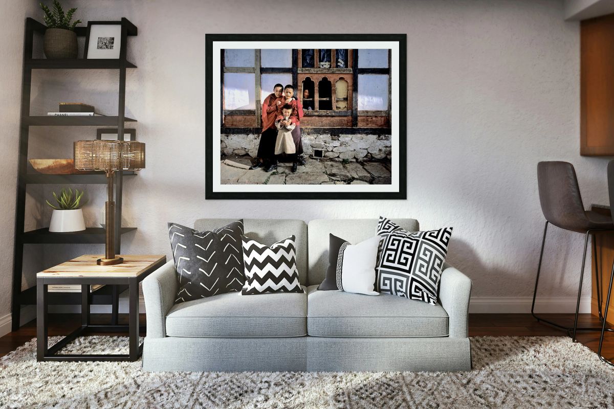 Children embracing one holding toy gun outside traditional bui