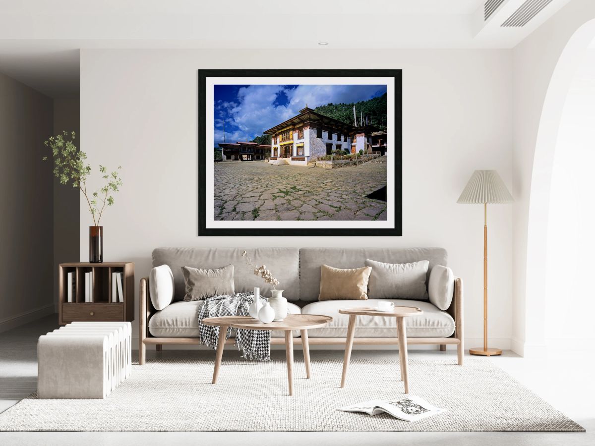Traditional Bhutanese building with stone courtyard under a clou