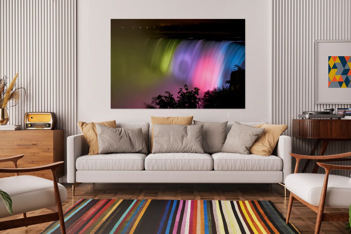 Niagara Falls illuminated with vibrant colors at night.