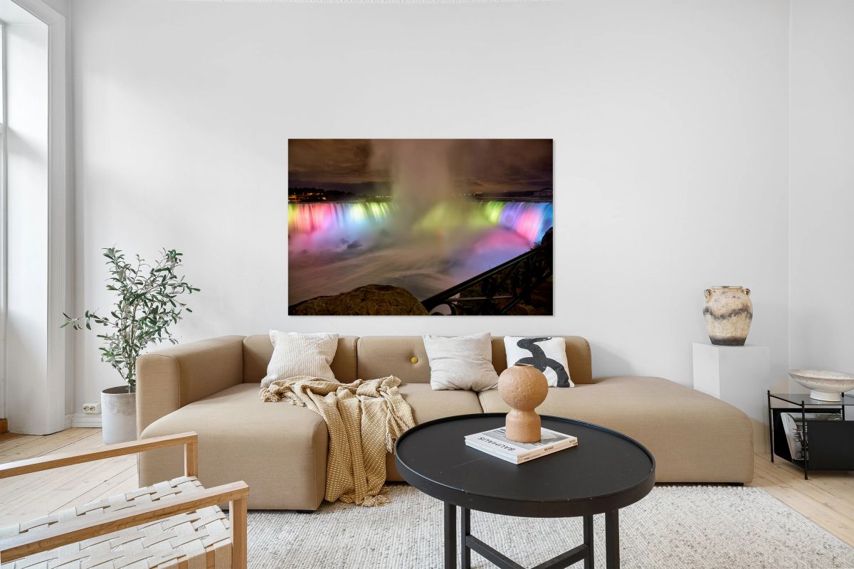 Niagara Falls illuminated at night with colorful lights.
