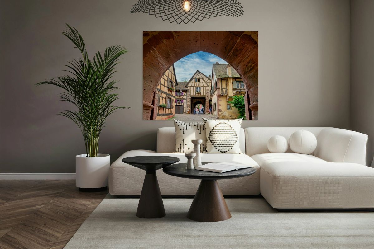 Visitors walk through an archway in Riquewihr
