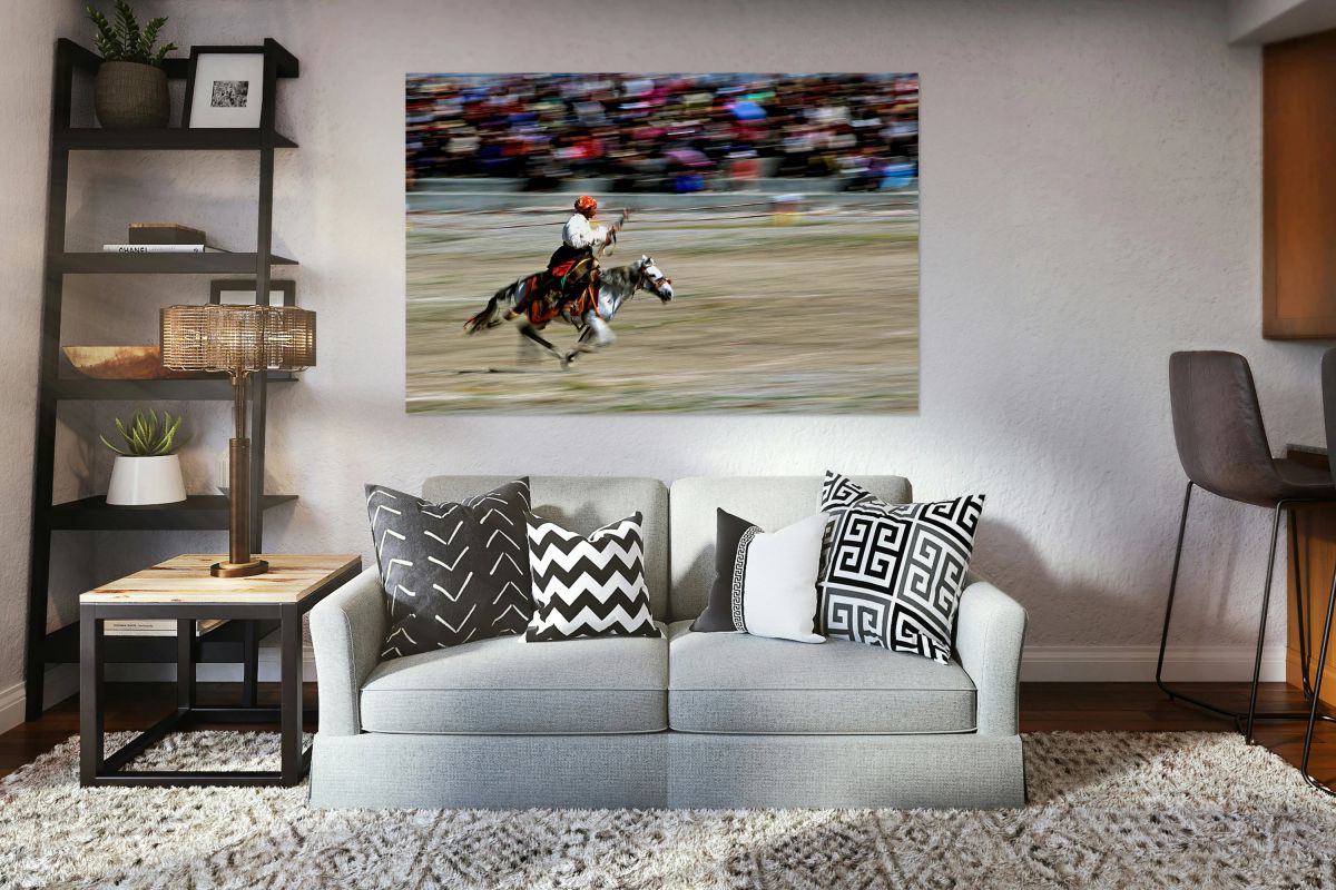 Equestrian rider on a horse races in front of a large crowd in T