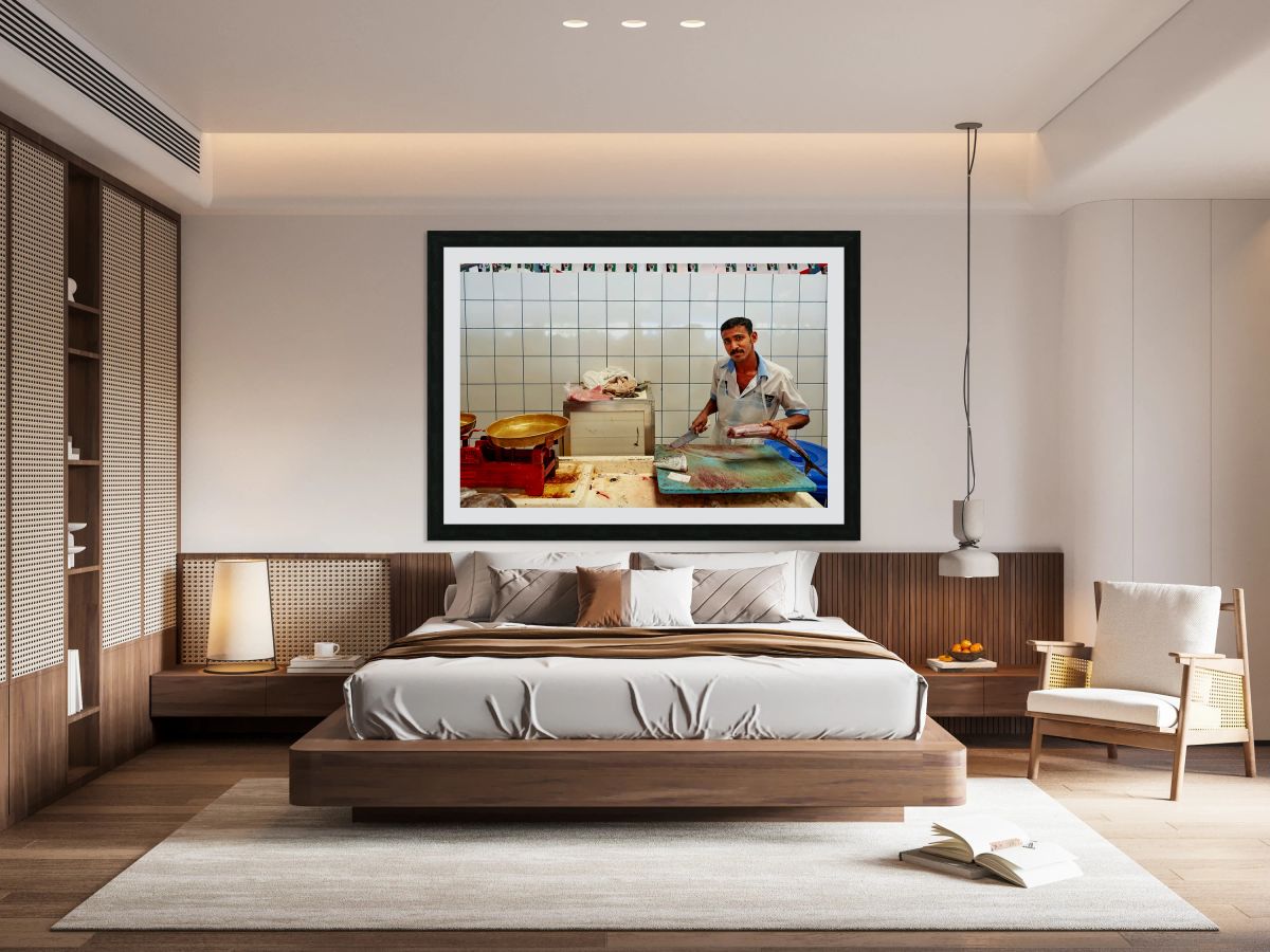 Man cuts fish at a market stall in Dubai during daylight hours