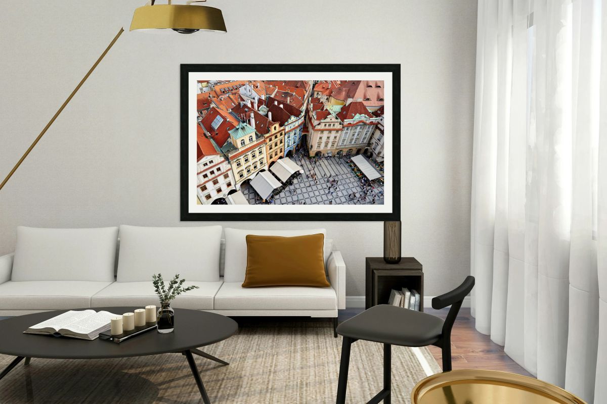 Aerial view of a bustling European city square with red roofs.