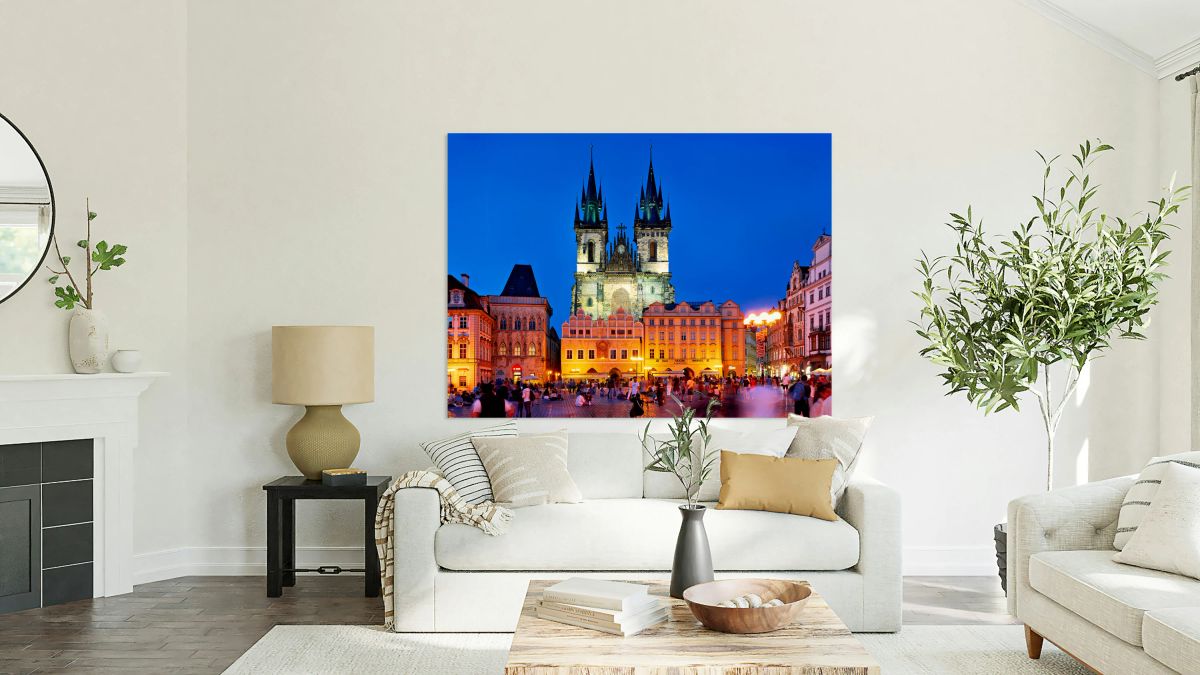 Pragues Old Town Square at night illuminated church and crowd.