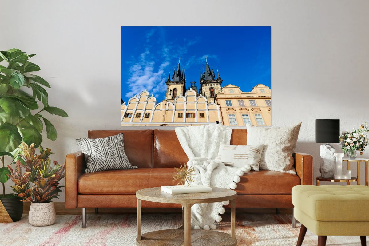 Týn Church spires and historic Prague buildings against blue sk